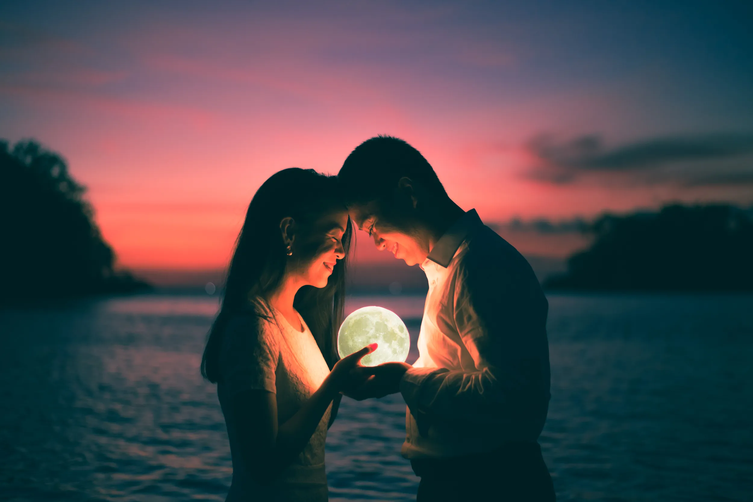 Majal and Regine holding the moon at night